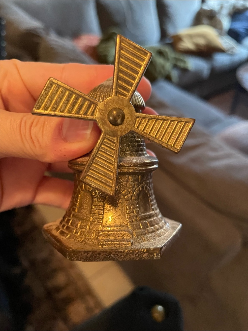 Vintage brass windmill-shaped table bell with rotating blades.